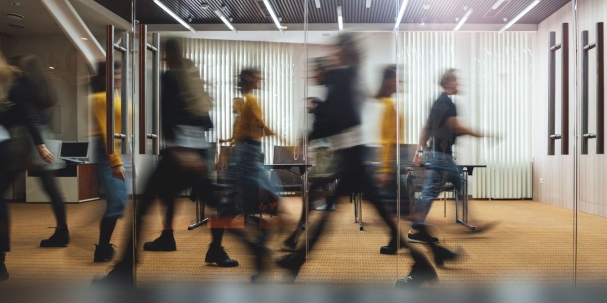 Blurry people walking around an office space