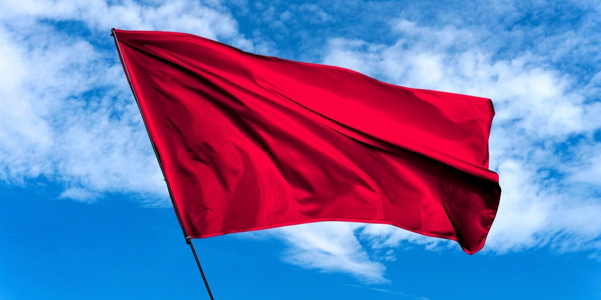 Red flag waving in sky