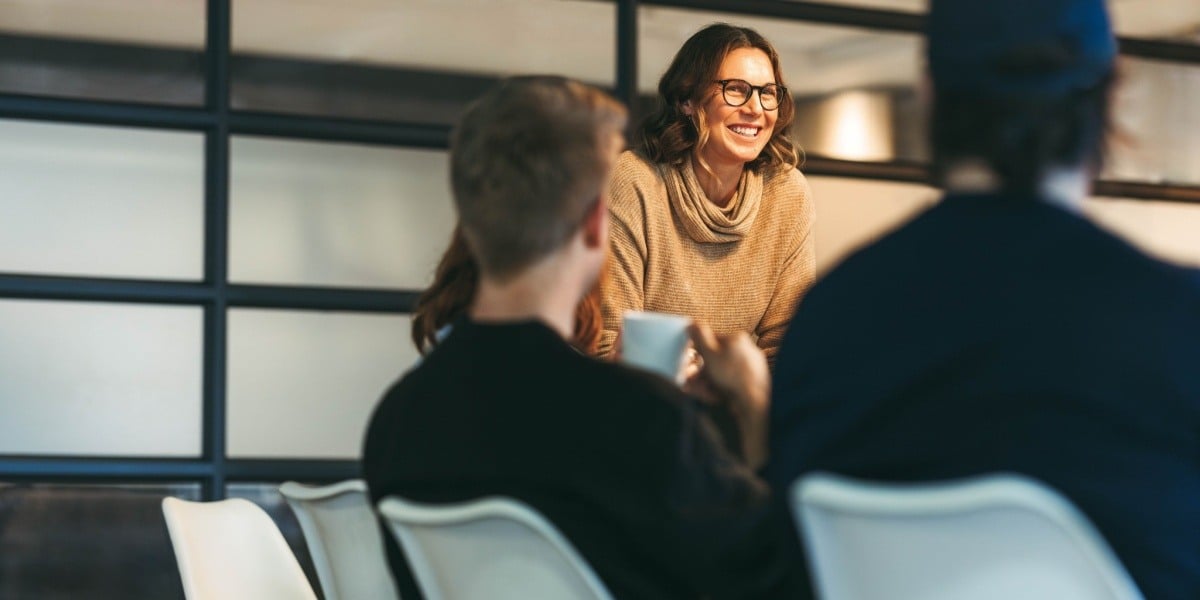 Businesswoman standing at head of table 