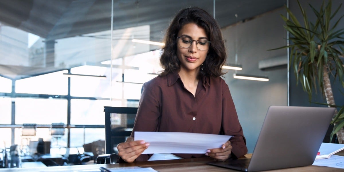 Businesswoman reading papers at a desk