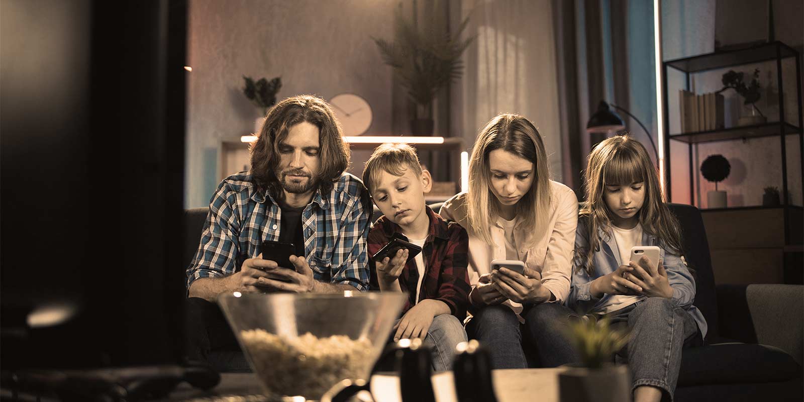 Distracted family members staring at their phones on the couch